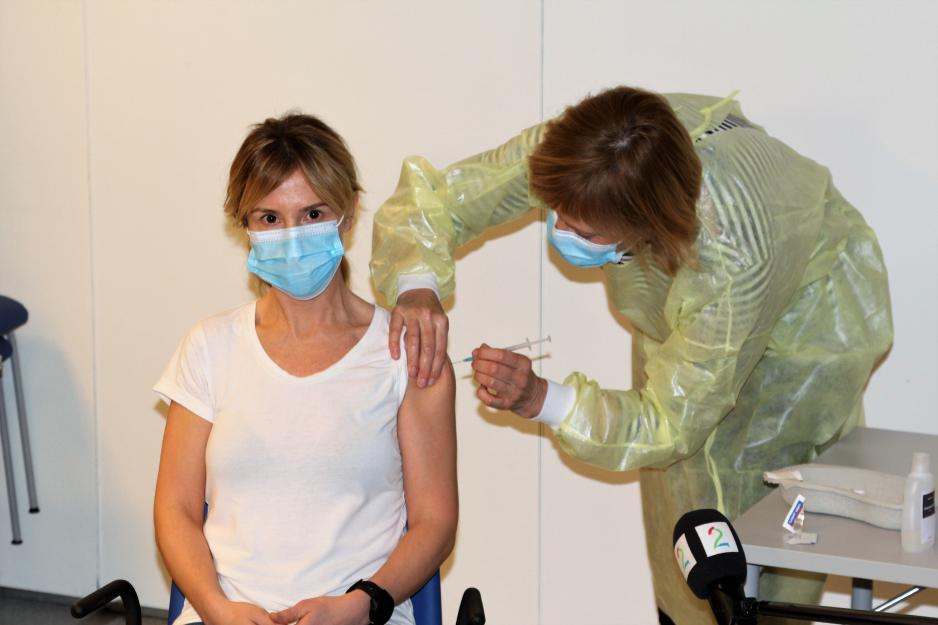 Fastlege i Bodø kommune, Kine Kalstad fikk den første Covid-vaksinen i Bodø av vaksinesjef Karin Wiik. (Foto: Trine Jonassen)