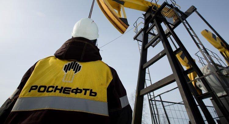 Rosneft employee looking at an oil well Rosneft employee looking at an oil well
