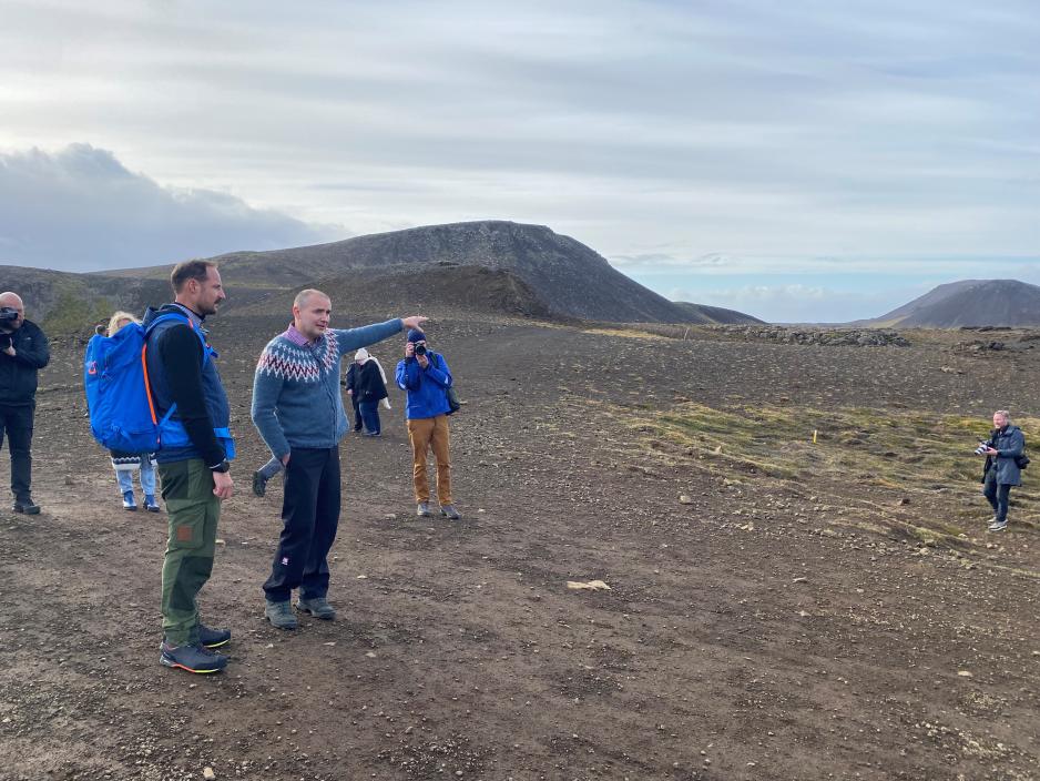 Kronprins Haakon og president av Island peker på vulkanutbruddet.