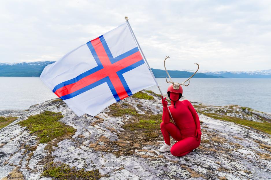 Færøyene (Føroyar) sitt flagg heter Merkið (‘merket’). Dette ble lansert på øygruppa i 1919 av færøyske studenter i København. Da Færøyene ble besatt av Storbritannia i 1940 (2. vk.), krevde britene at færøyske skip ikke skulle seile under dansk flagg – og slik ble Merkið tatt i bruk. Først i 1948 ble flagget offisielt. Dets hvite bunn symboliserer klar himmel og bølger som bryter mot kysten. Det røde og blå finnes i det tradisjonelle færøyske skjerfet – og henspiller også på tilknytningen til Island og Norge. (Foto: Nordting/Jamie Michael Bivard)