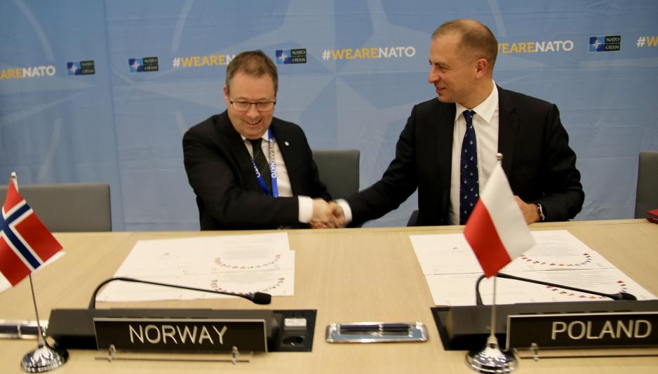Forsvarsminister Bjørn Arild Gram (Sp) og Polens Nato-representant, Tomasz Szatkowski under signeringsmøtet for intensjonsavtalen om øving og trening over landegrenser i Natos luftdomene. (Foto: Nato) Bjørn Arild Gram og Tomasz Szatkowski