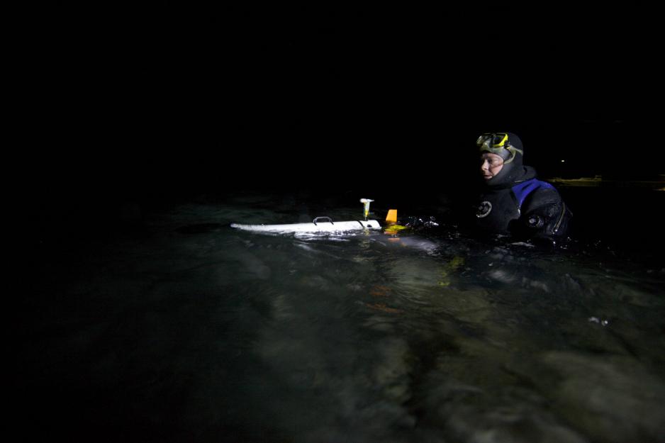 Professor Jørgen Berge i vannet med en av robotene som ble brukt – en AUV (Autonomous Underwater Vehicle). . Foto: Geir Johnsen, NTNU.