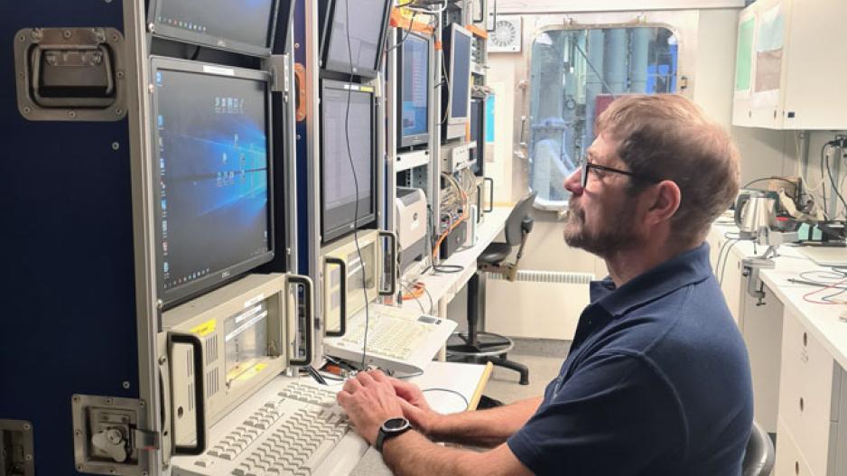 Per Trinhammer fra Geological Survey of Denmark and Greenland kalibrerer utstyret i datamottakskontaineren som skal registrere viktig informasjon når de seismiske undersøkelsene er i gang. Tidspunktet når luftkanonen avfyrer sin lydbølge må registreres helt nøyaktig for at dataene skal kunne stoles på. Per Trinhammer ,GEUS. GoNorth