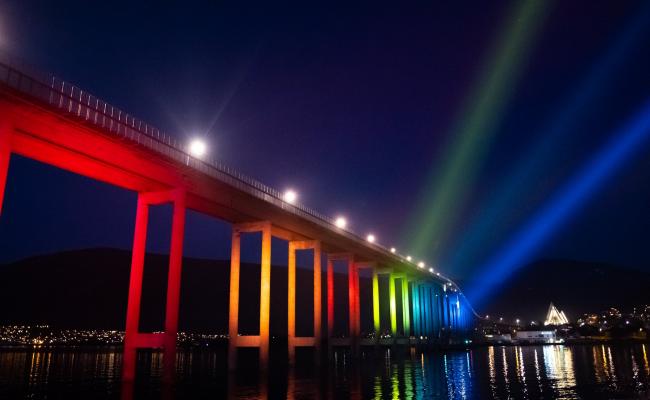 FNs bærekraftsmål. Tromsøbrua lyssatt med shavskatedralen i bakgrunnen