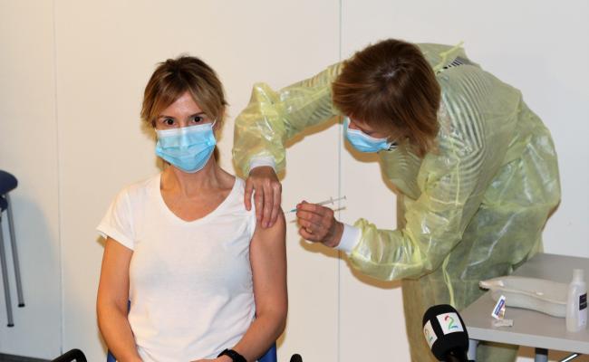 Fastlege i Bodø kommune, Kine Kalstad fikk den første Covid-vaksinen i Bodø av vaksinesjef Karin Wiik. (Foto: Trine Jonassen)