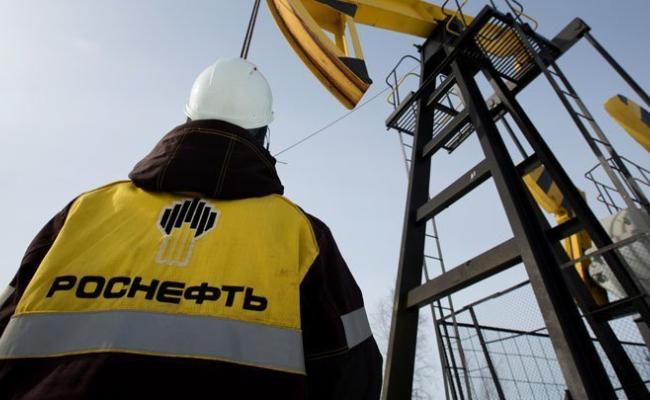 Rosneft employee looking at an oil well Rosneft employee looking at an oil well