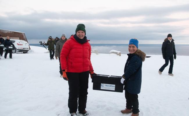 Utviklingsminister Anne Beathe Tvinnereim (Sp) og landbruks- og matminister Sandra Borch (Sp) bar den første kassa med frø inn i frølageret til Svalbard globale frøhvelv