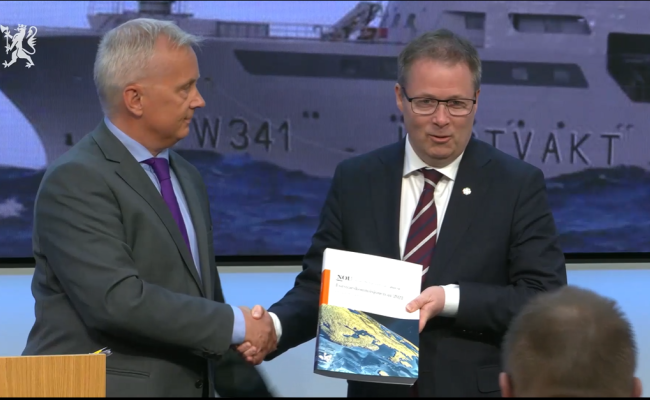 Knut Storberget gir Forsvarskommisjonens rapport til forsvarsminister Bjørn Arild Gram. (Skjermbilde fra pressekonferansen) Skjermbilde overlevering av Forsvarskommisjonens rapport